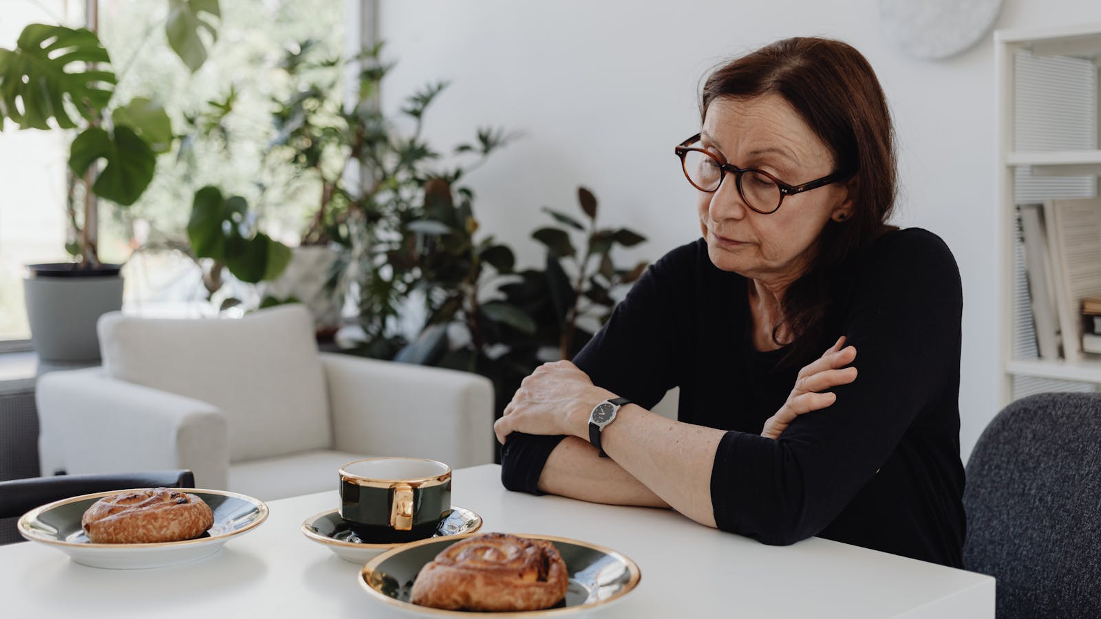 Un accompagnateur et un aîné partageant un thé à la table de la cuisine
